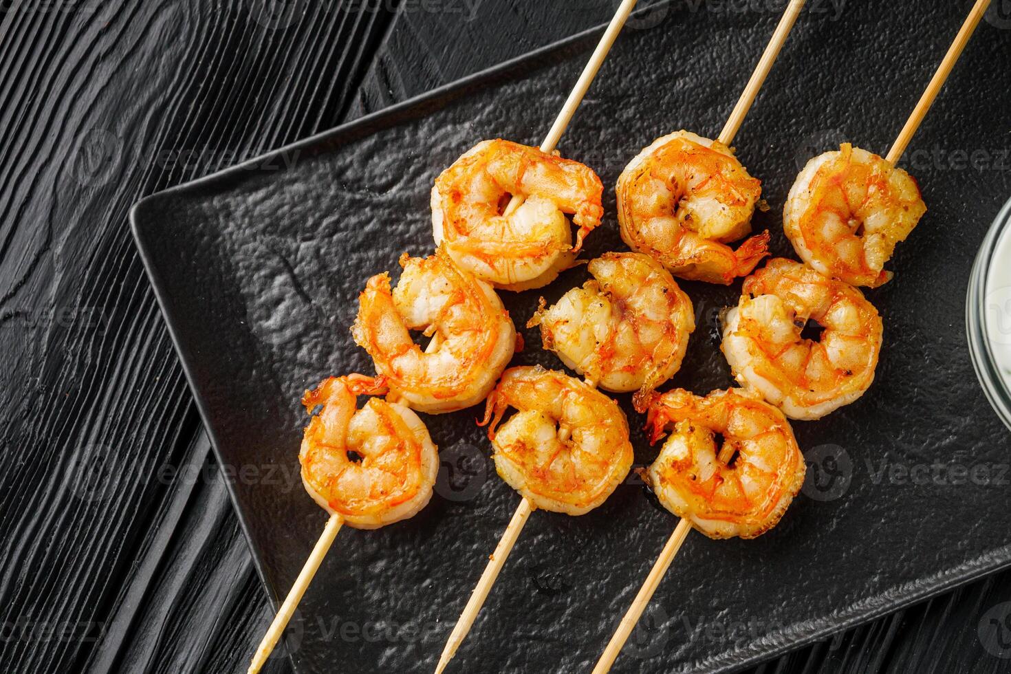 delicious grilled shrimp appetizer on a black wooden rustic background photo
