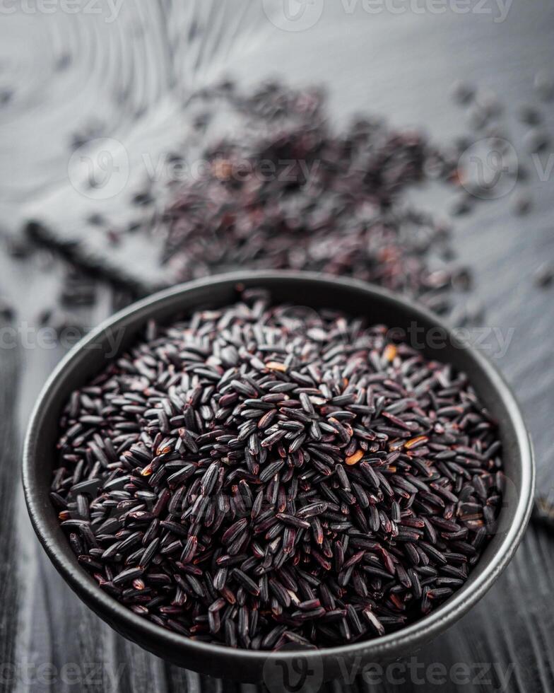 raw fresh black rice on black wooden rustic background photo