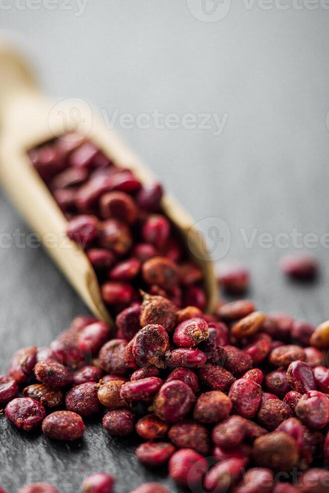 dry aromatic sumac spice on a black stone background photo