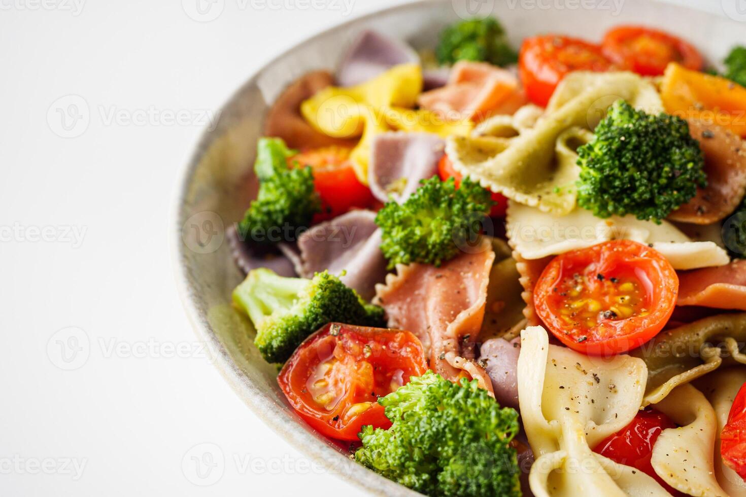 delicious colored farfalle pasta on a white background photo