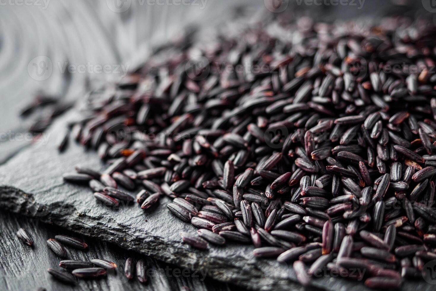 raw fresh black rice on black wooden rustic background photo