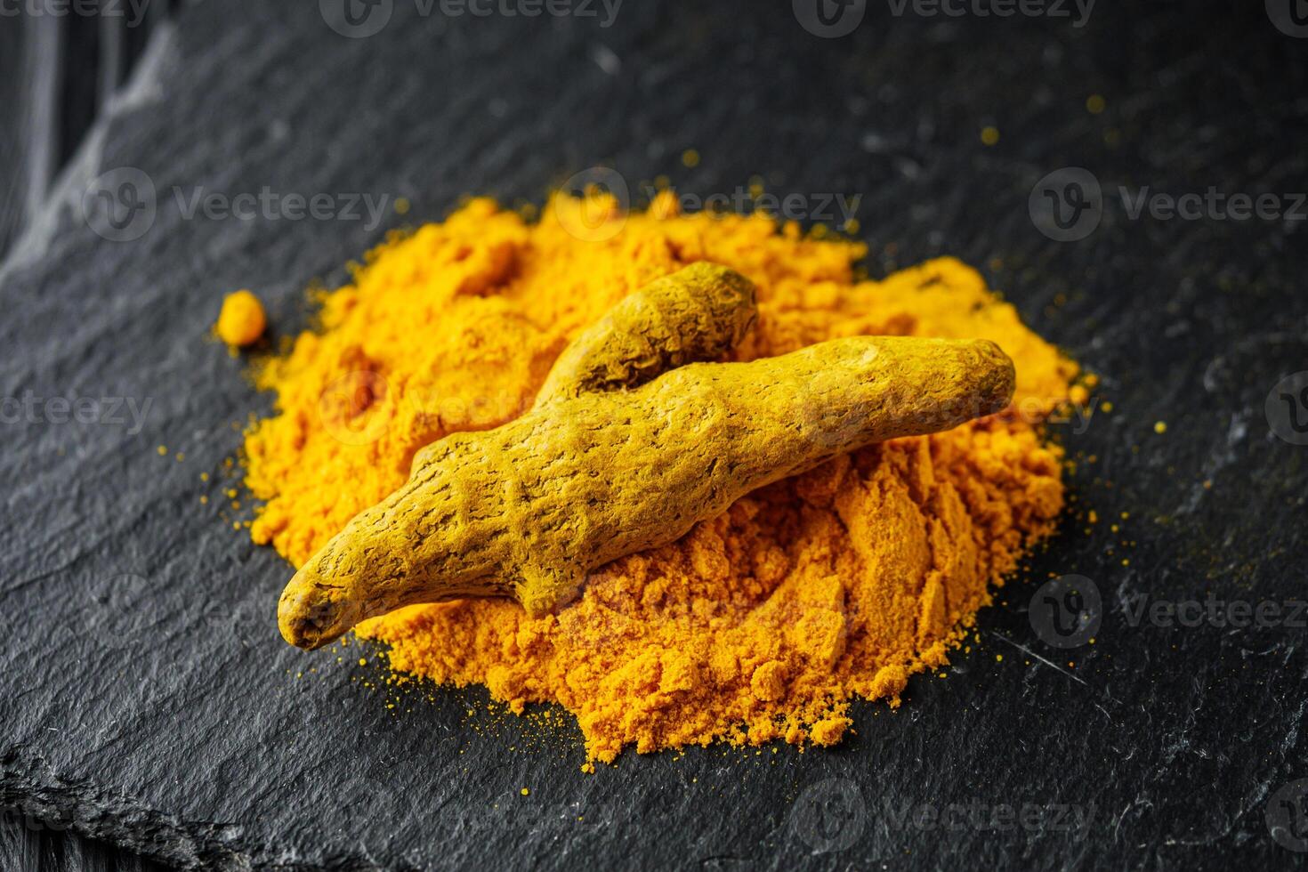 aromatic turmeric root on a black wooden rustic background photo