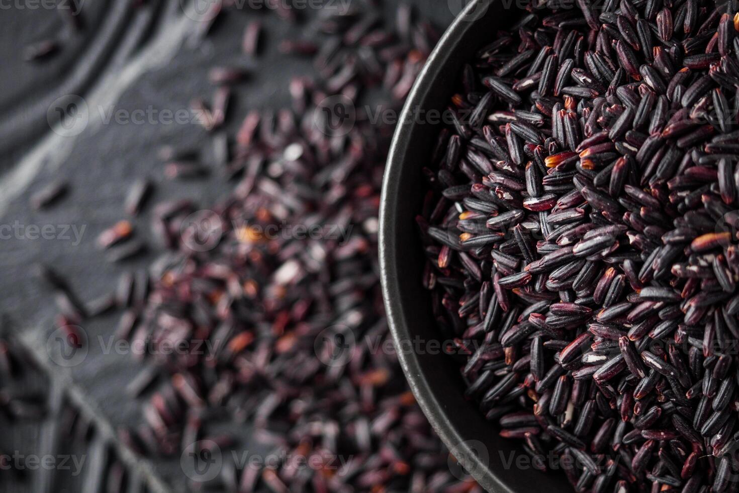 raw fresh black rice on black wooden rustic background photo