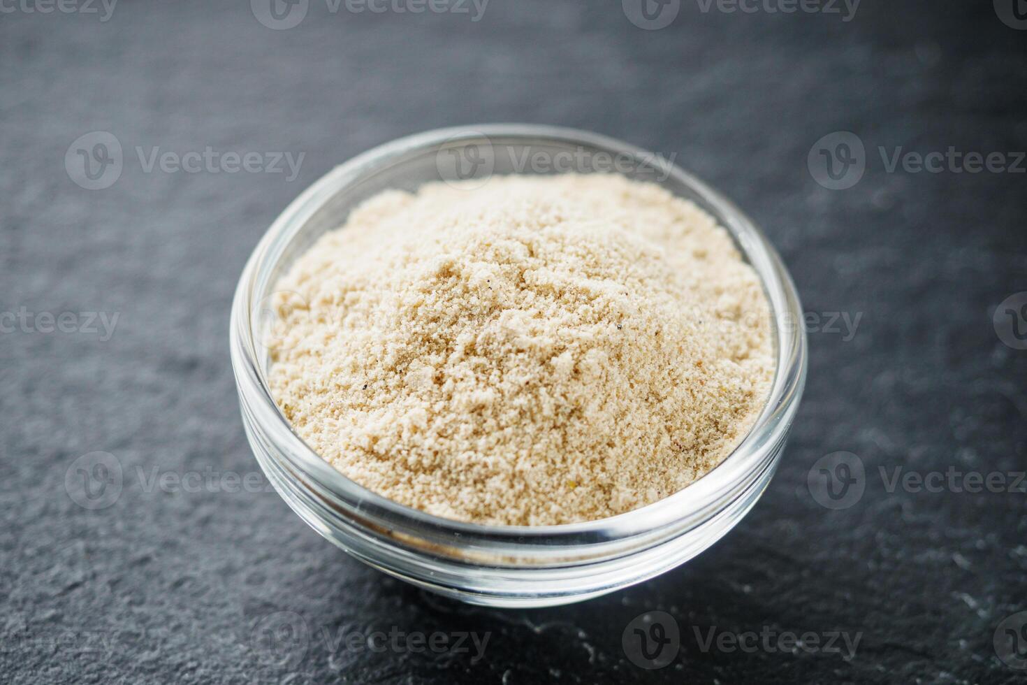 asafoetida aromatic powder on a black stone background photo