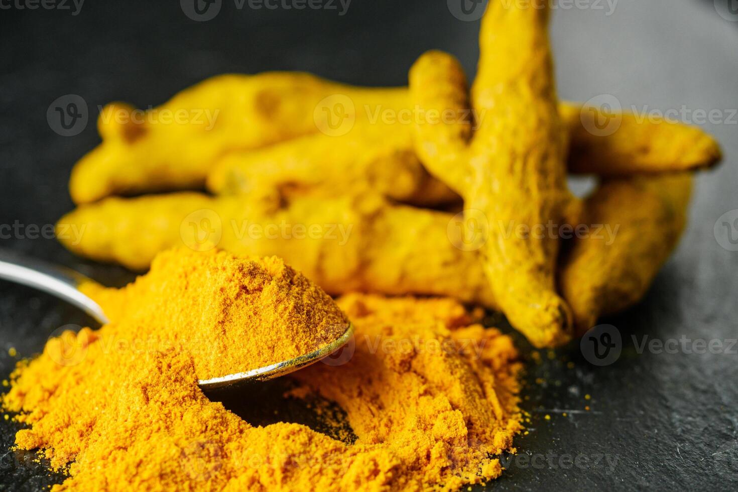 aromatic turmeric root on a black wooden rustic background photo