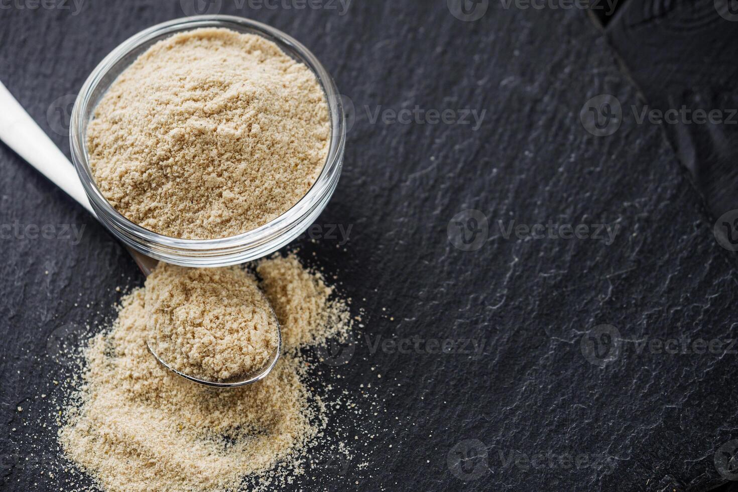 asafoetida aromatic powder on a black stone background photo