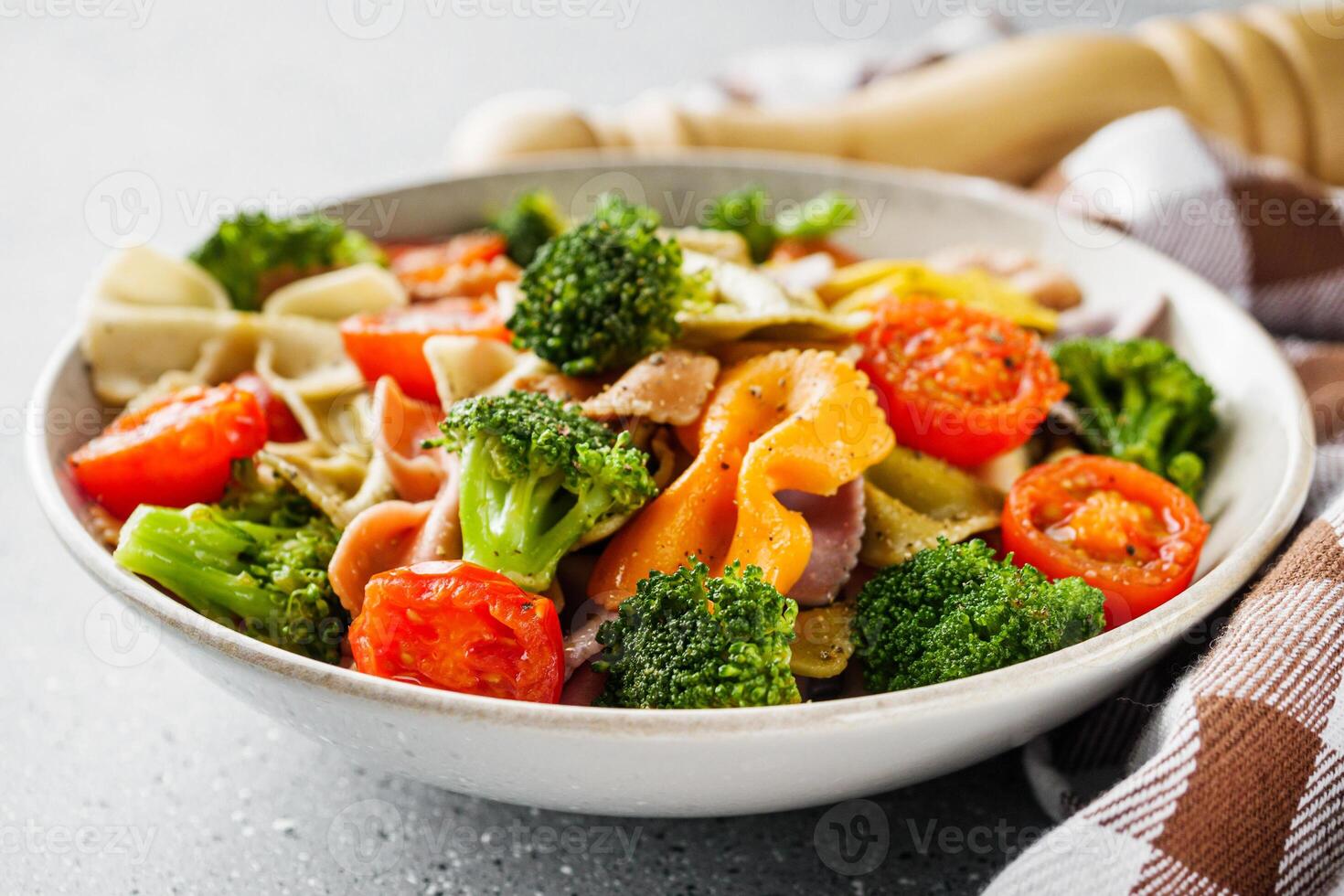 delicious colored farfalle pasta on a stone background photo