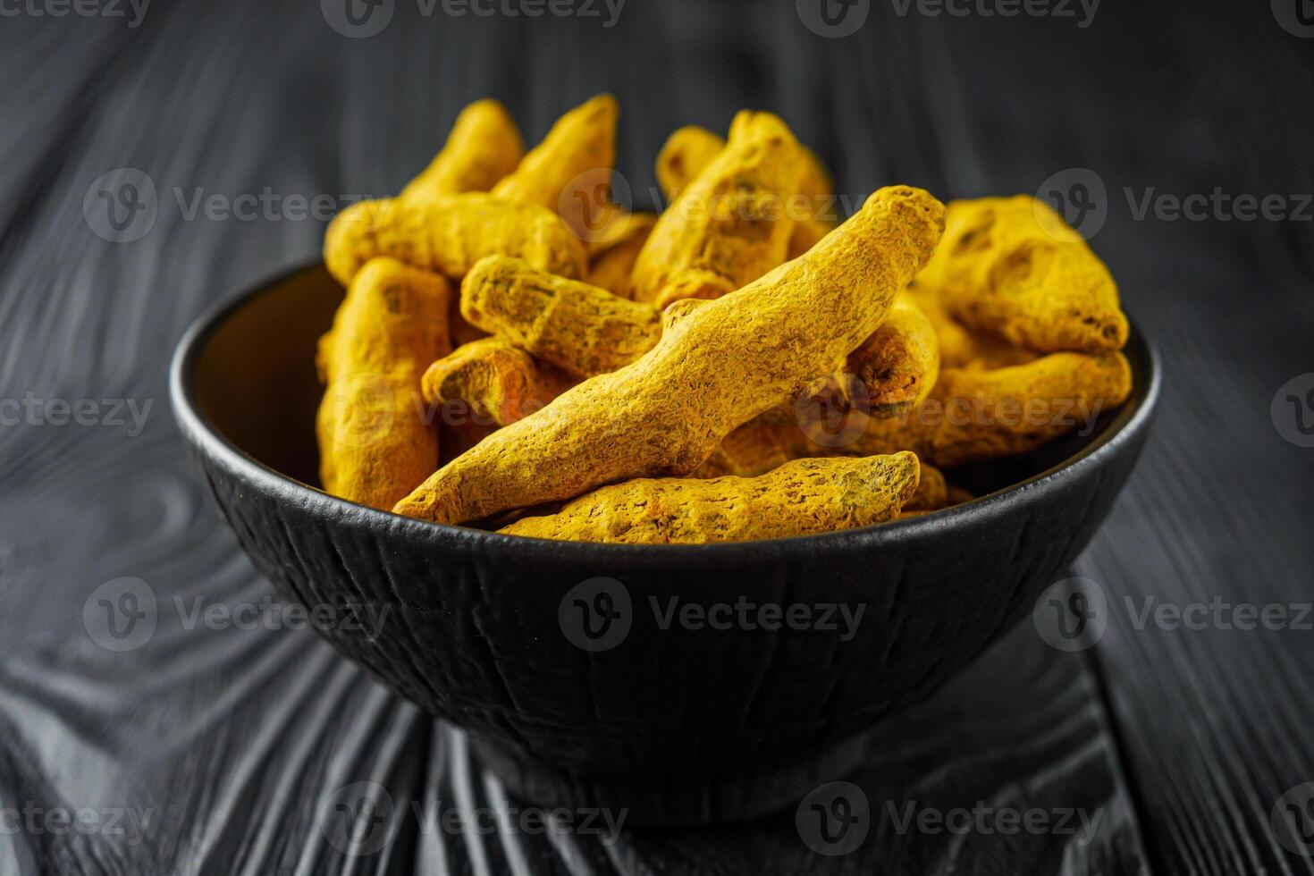 aromatic turmeric root on a black wooden rustic background photo
