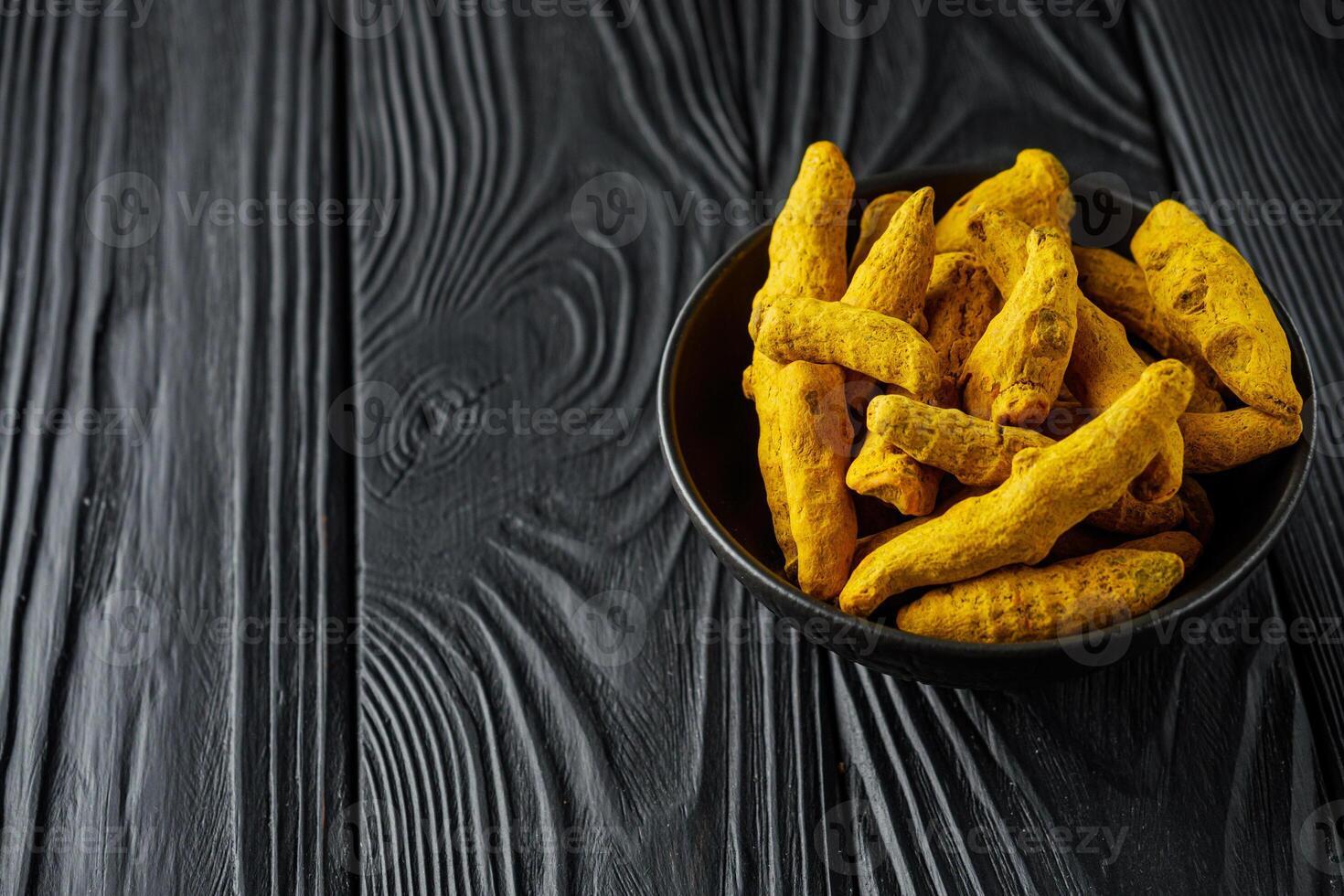 aromatic turmeric root on a black wooden rustic background photo