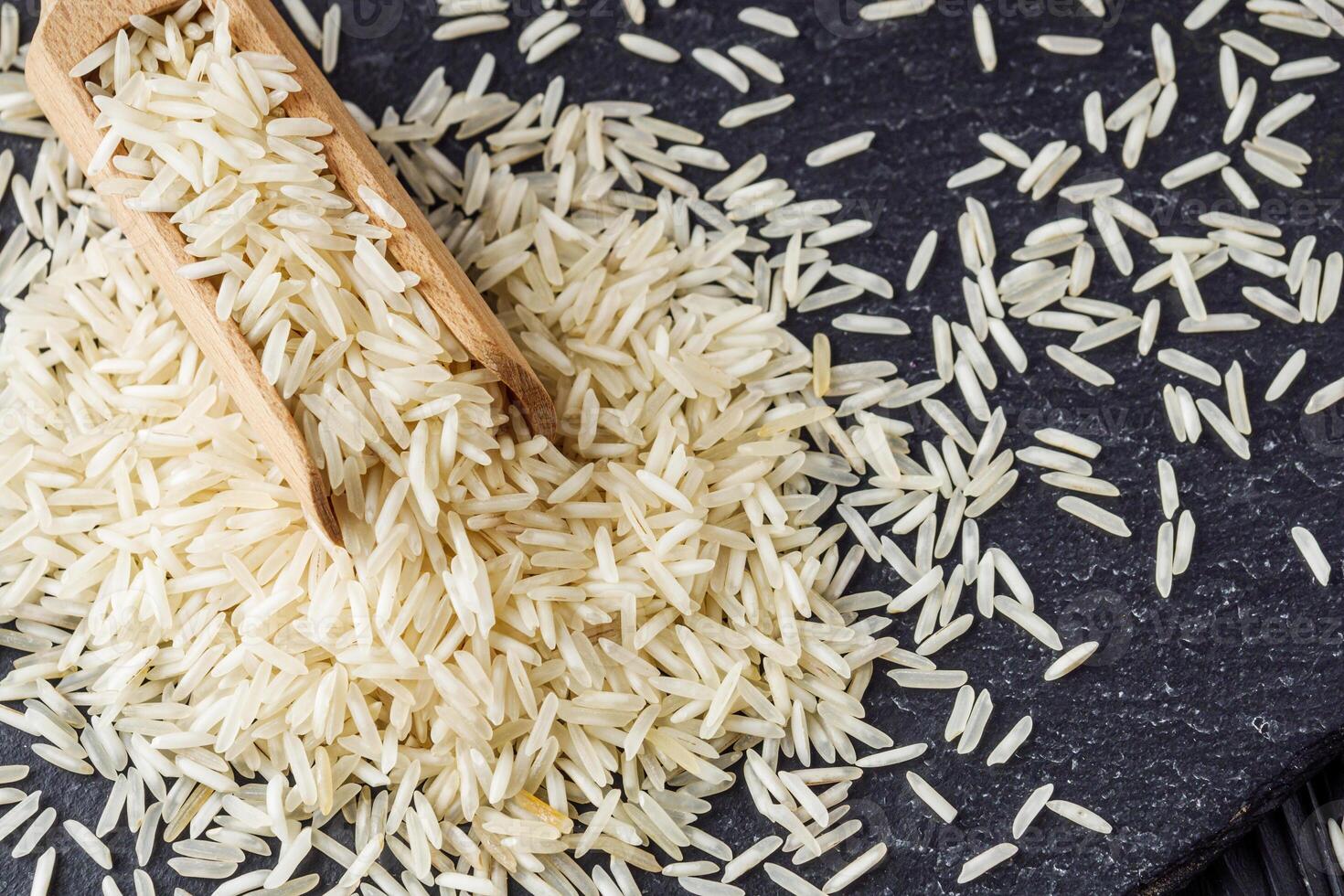 raw basmati rice on a black wooden background photo
