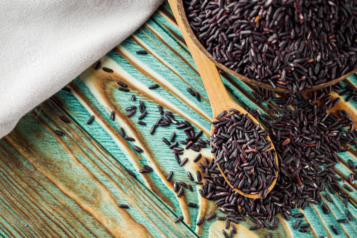 raw fresh black rice on wooden rustic background photo