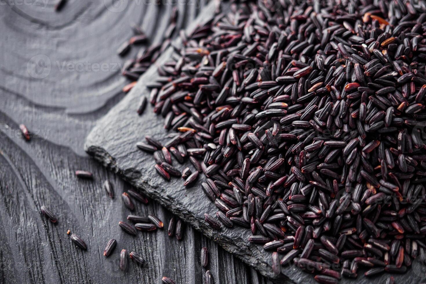 raw fresh black rice on black wooden rustic background photo