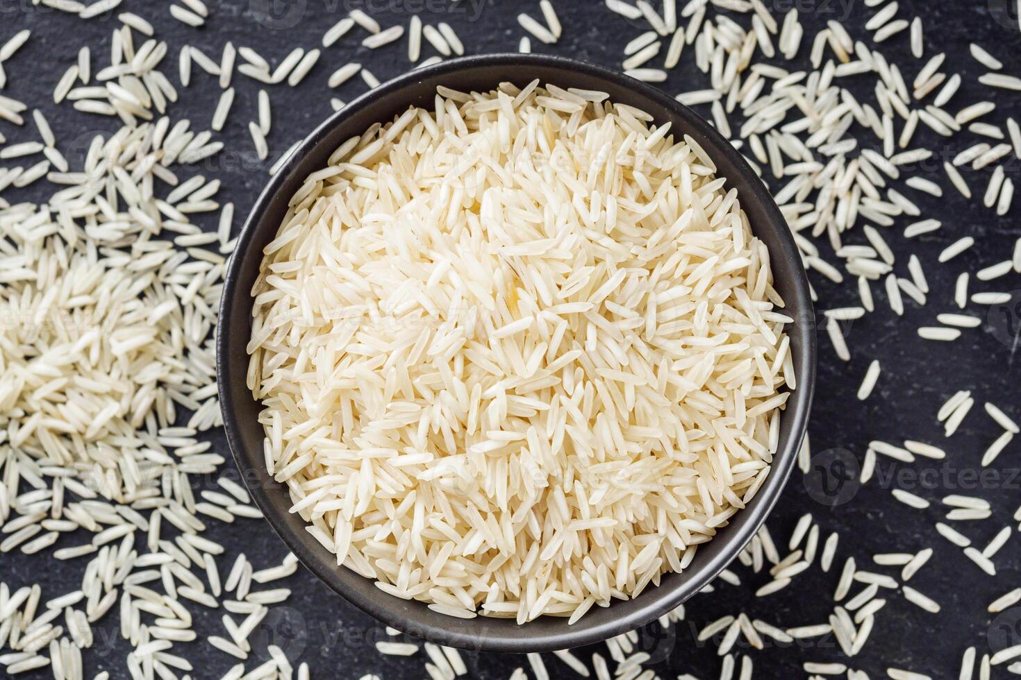 raw basmati rice on a black wooden background photo