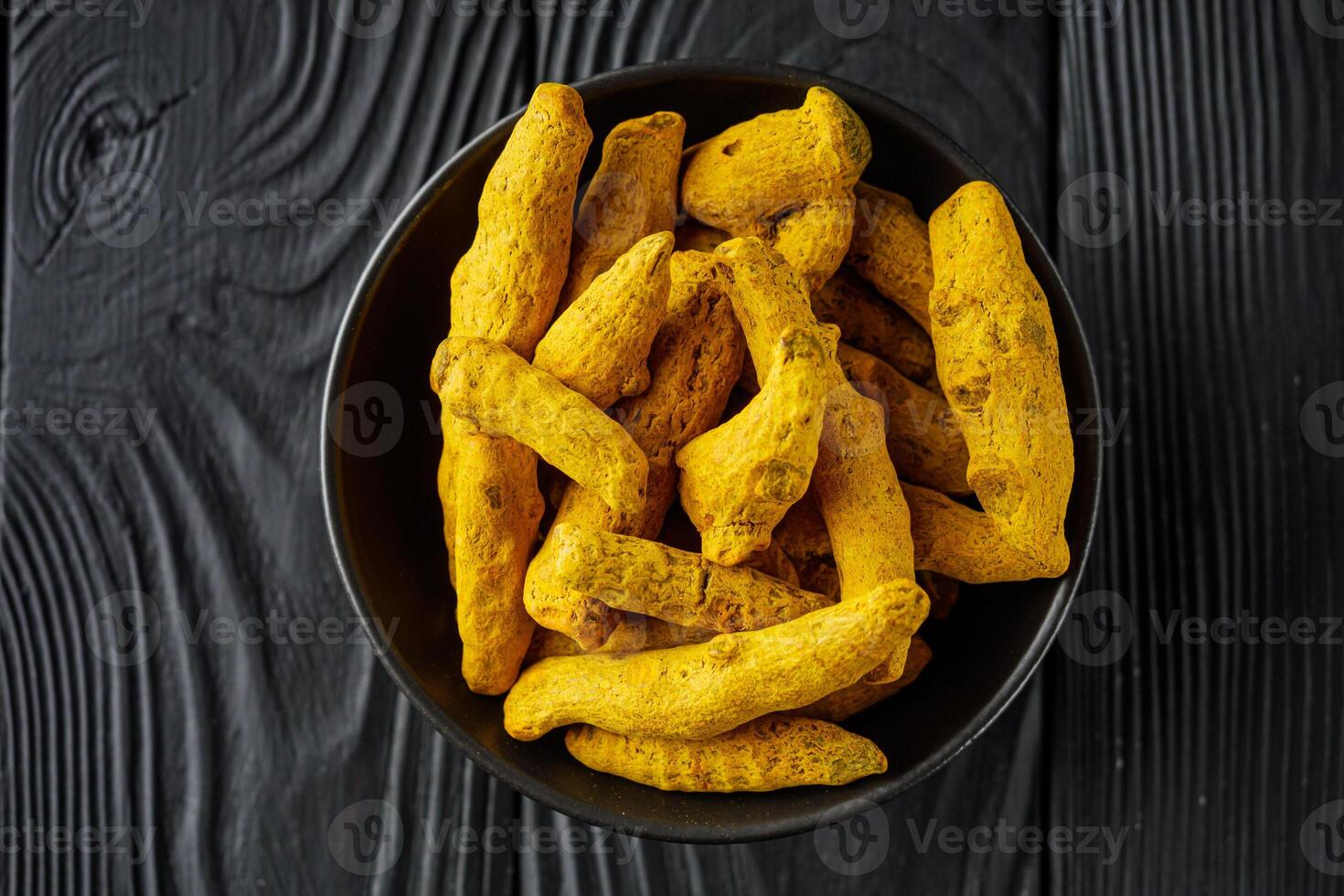 aromatic turmeric root on a black wooden rustic background photo