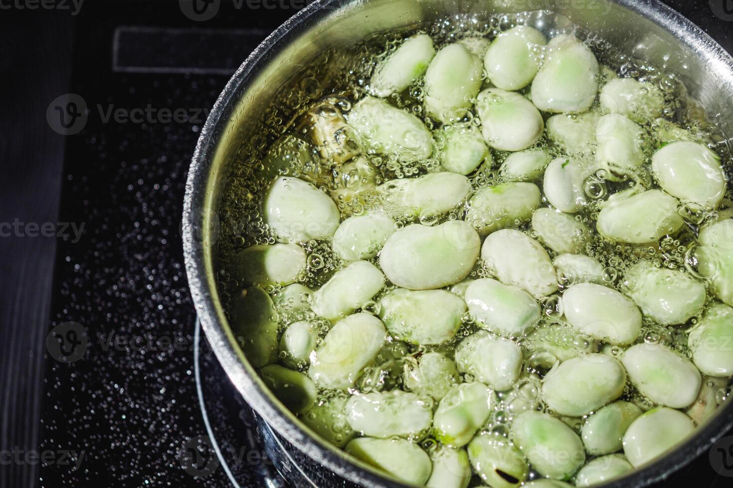 fresh greens broad beans fava boiled on a dark background photo