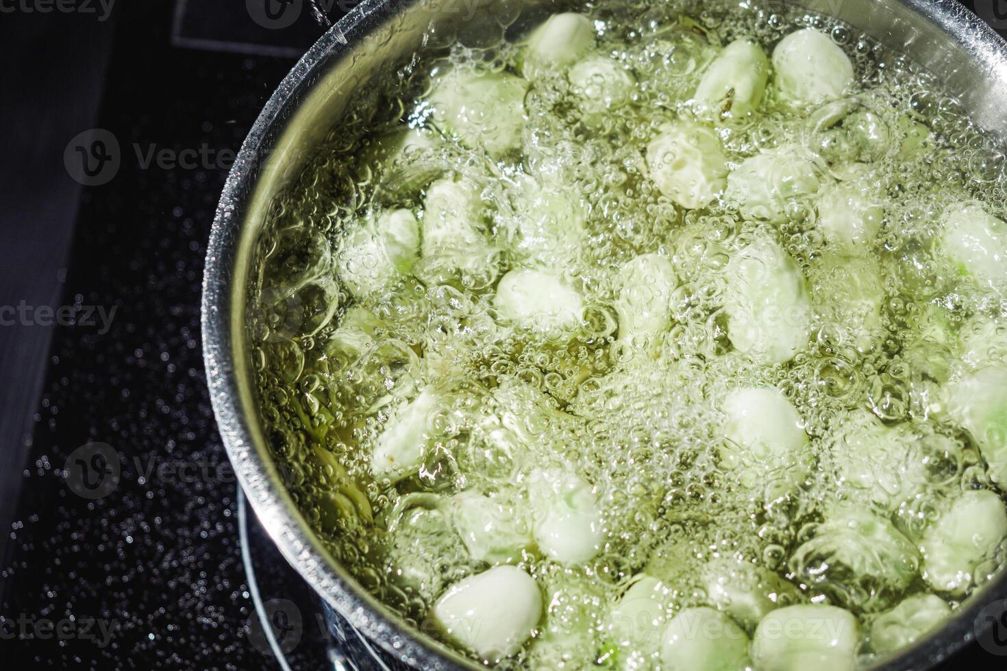 fresh greens broad beans fava boiled on a dark background photo