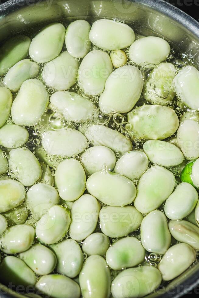 fresh greens broad beans fava boiled on a dark background photo