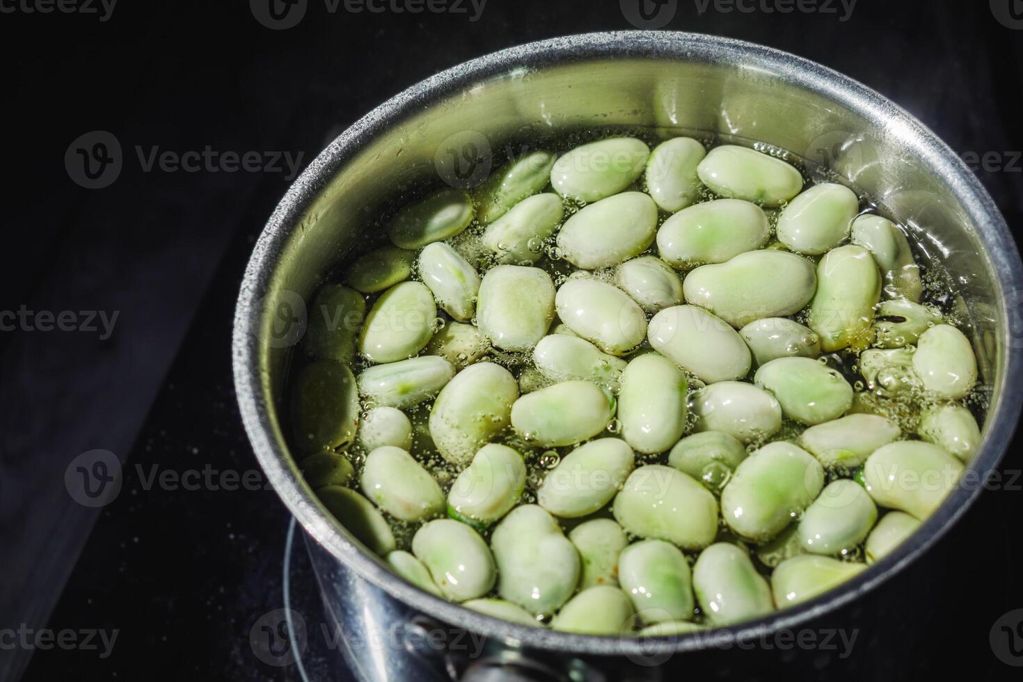 fresh greens broad beans fava boiled on a dark background photo