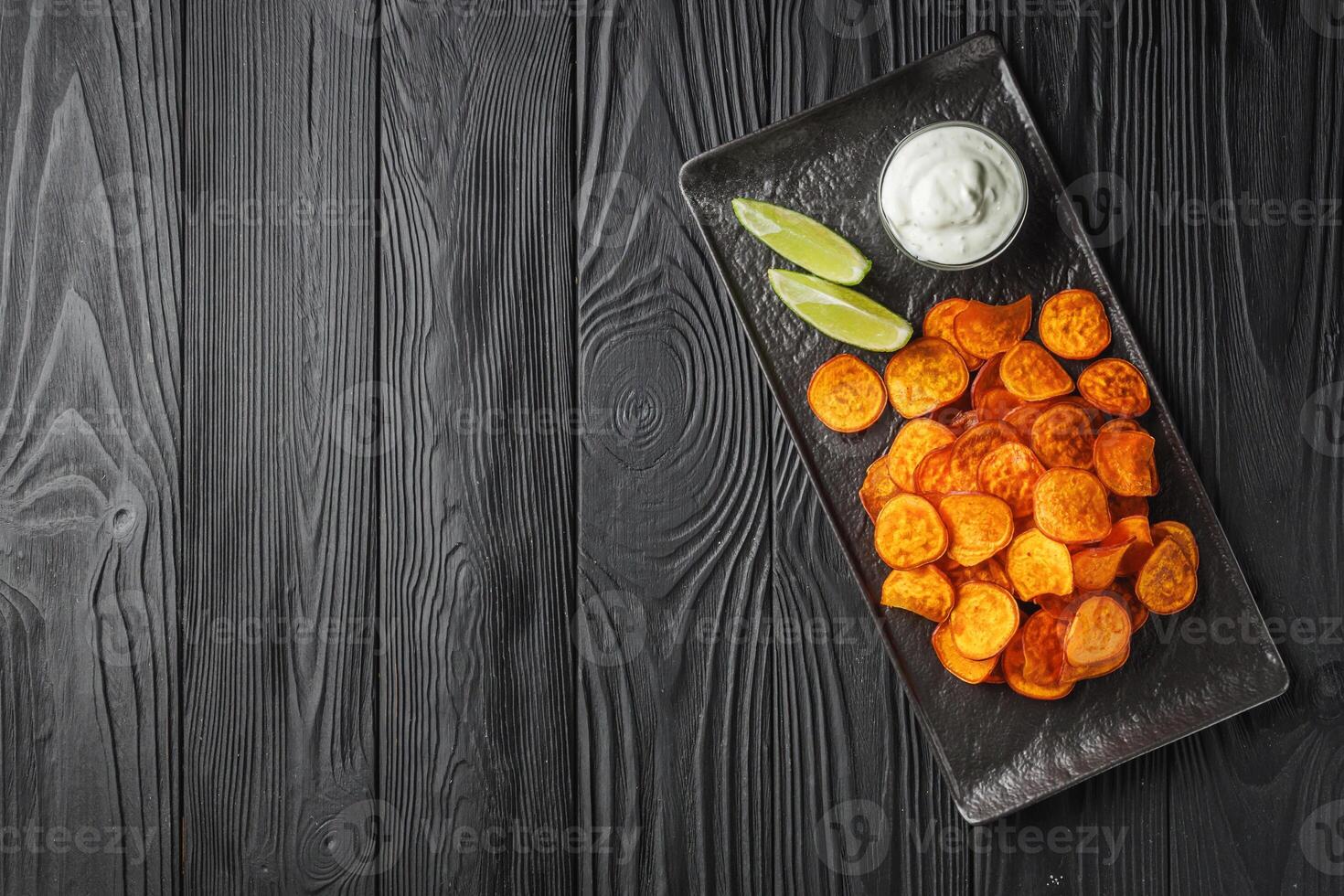 sweet potato chips on a dark wooden rustic background photo