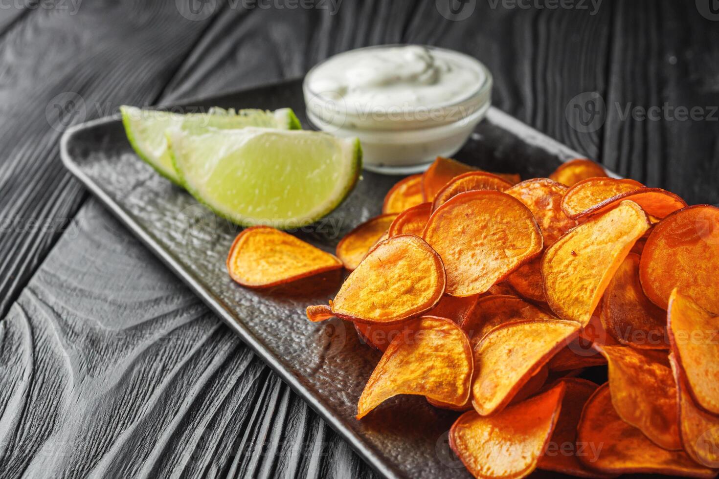 sweet potato chips on a dark wooden rustic background photo