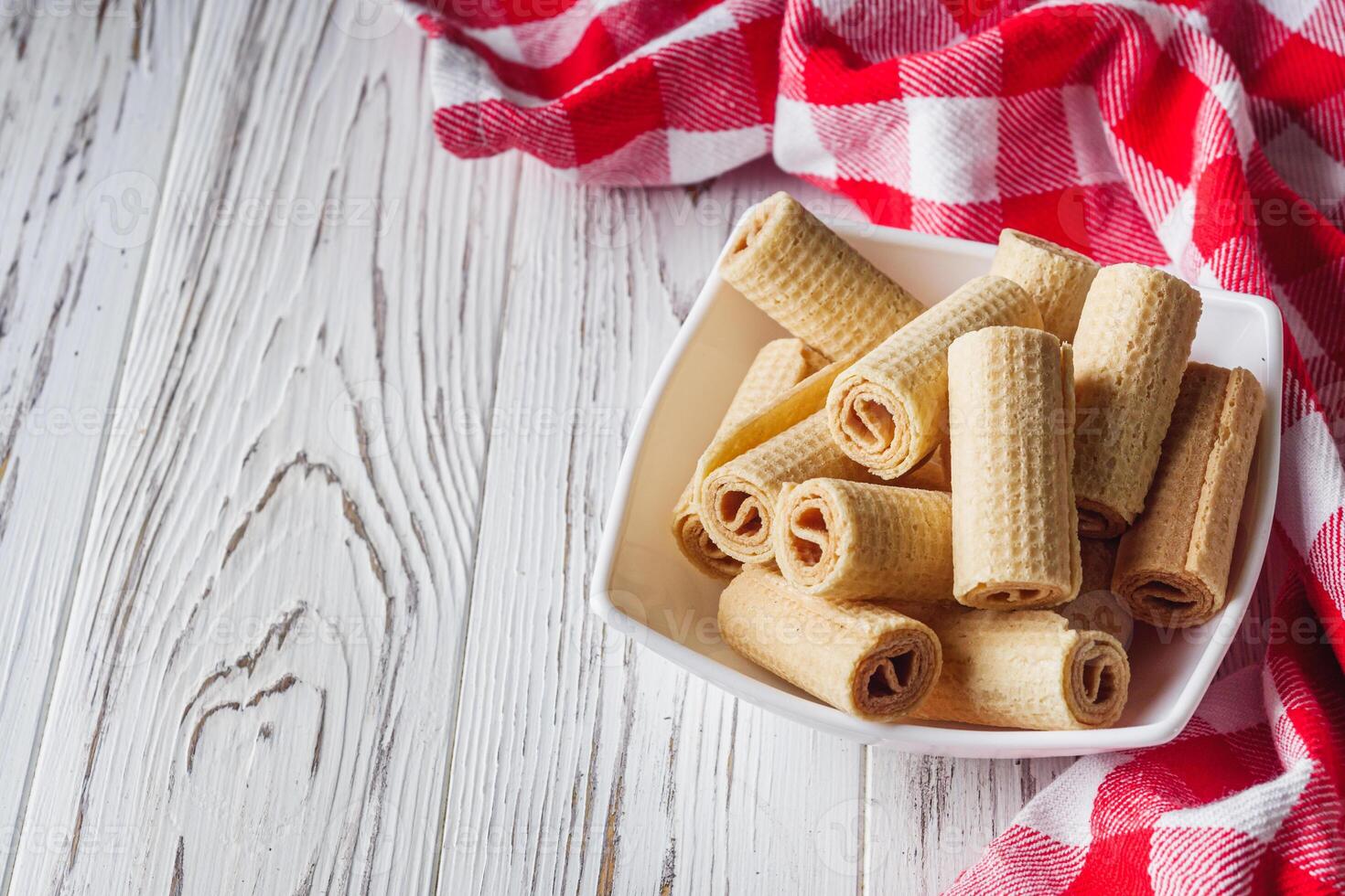 crispy dessert wafer rolls on a white wooden rustic background photo