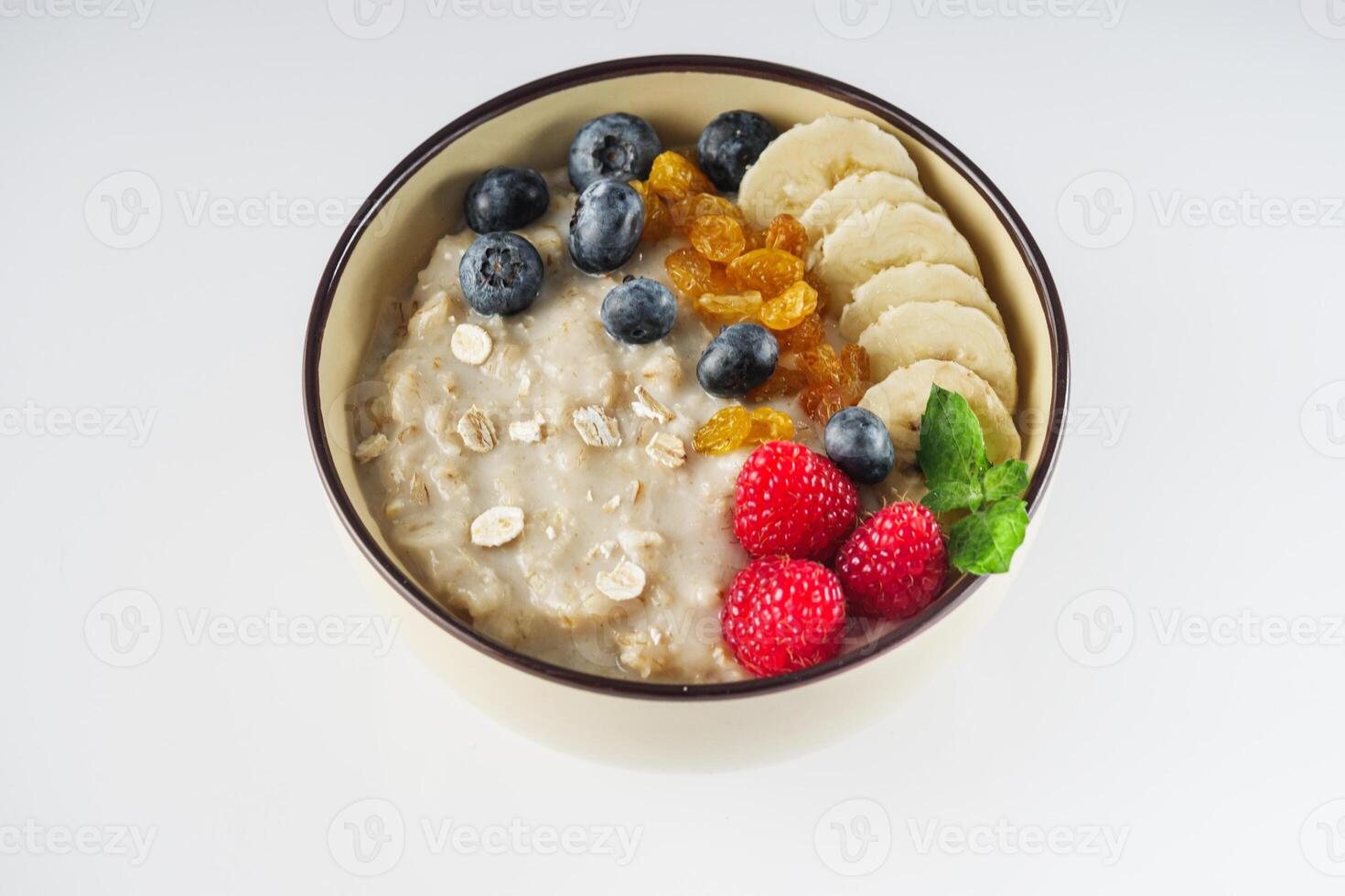 tasty nutritious oatmeal with fruits and berries on a white background photo