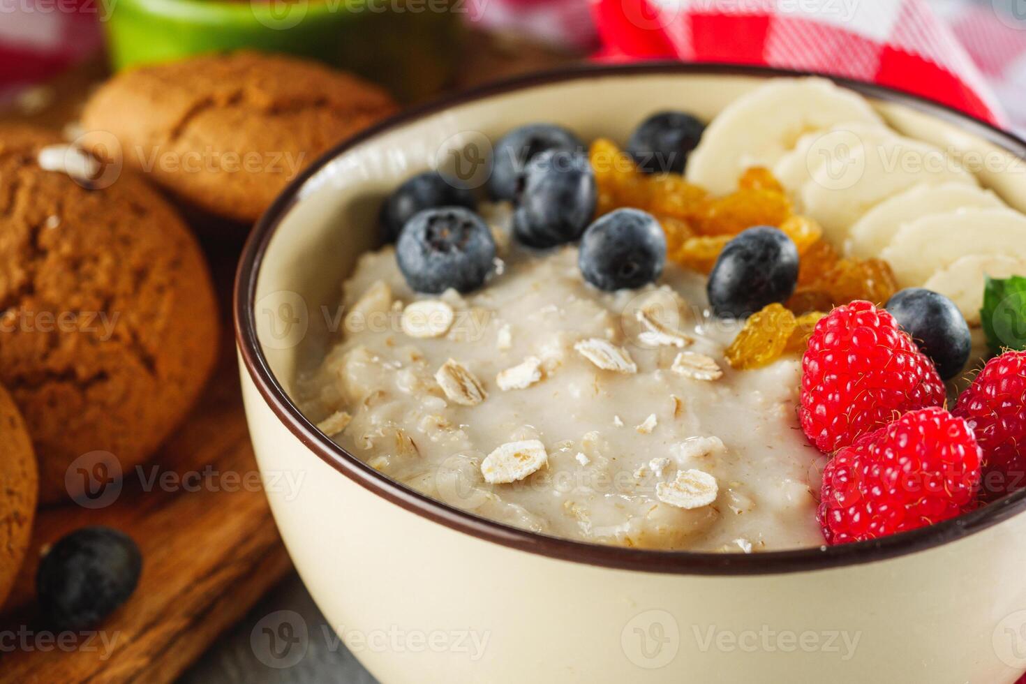 tasty nutritious oatmeal with fruits and berries on a light stone background photo