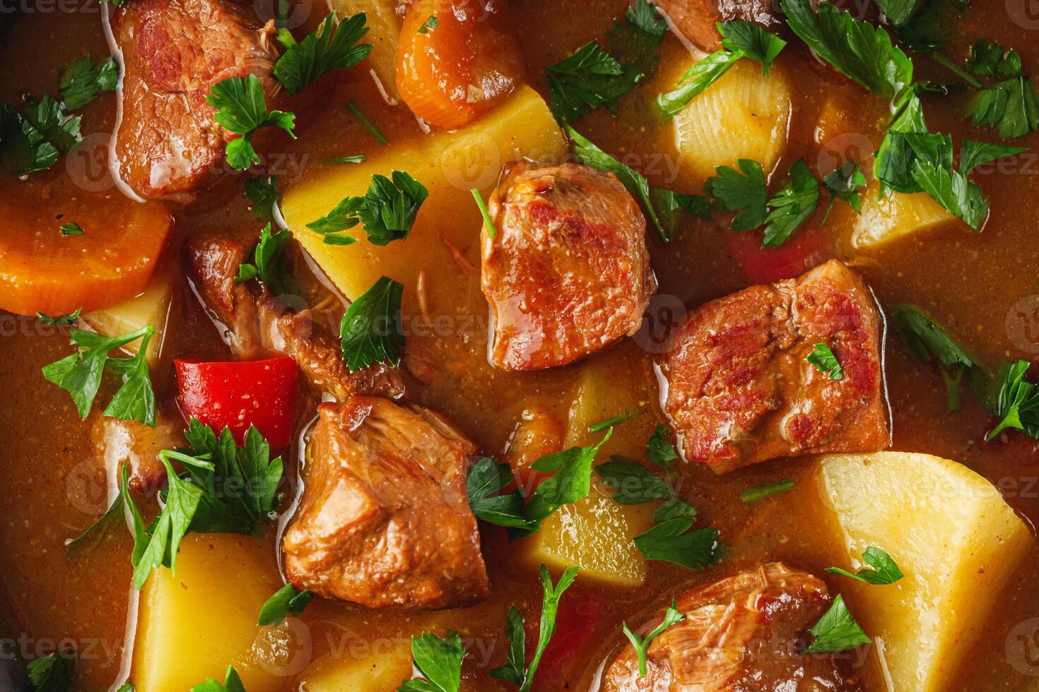 fragrant thick goulash soup on a black wooden rustic background photo