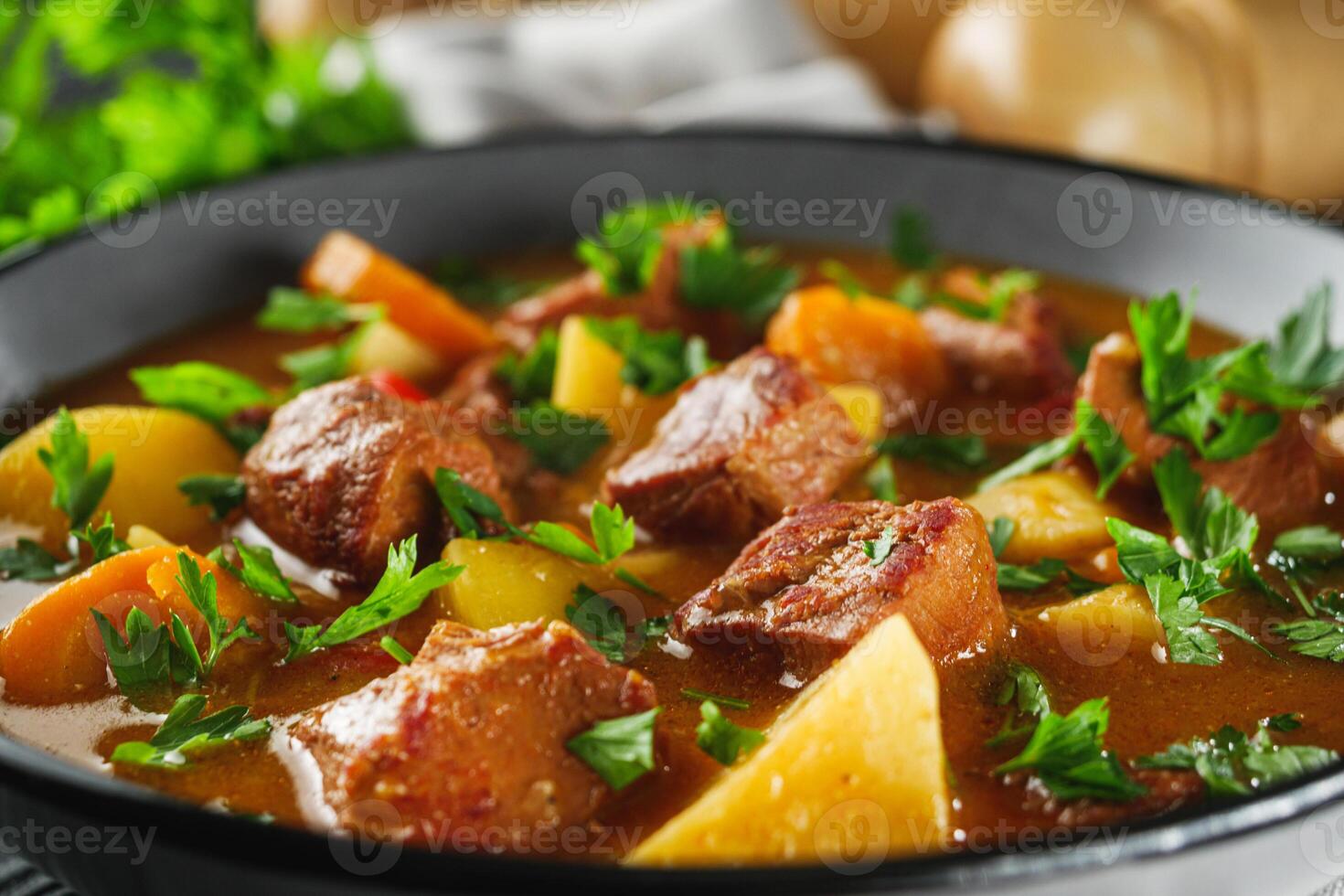 fragrant thick goulash soup on a black wooden rustic background photo