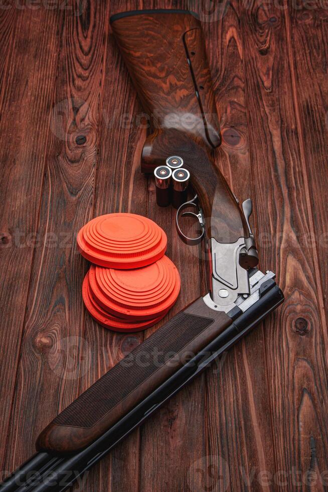 Clay target plates for shooting with rifle on wooden back photo