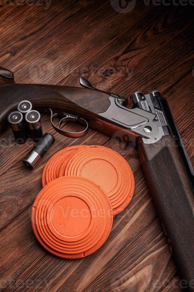 Clay target plates for shooting with rifle on wooden back photo