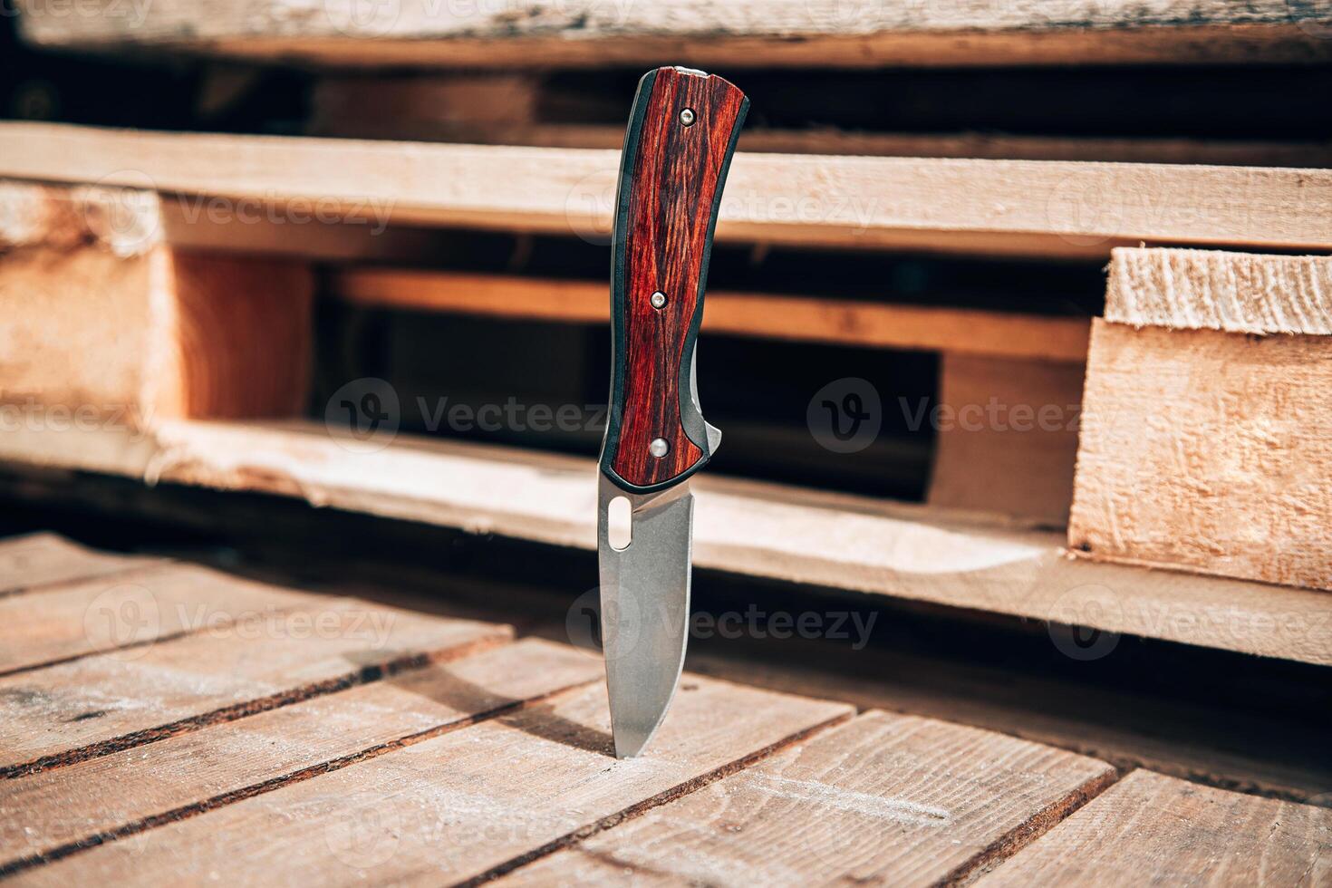 Folding pocket knife with wooden handle. A small knife on a wooden surface. photo