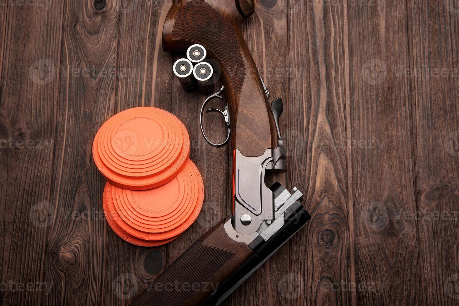 Clay target plates for shooting with rifle on wooden back photo