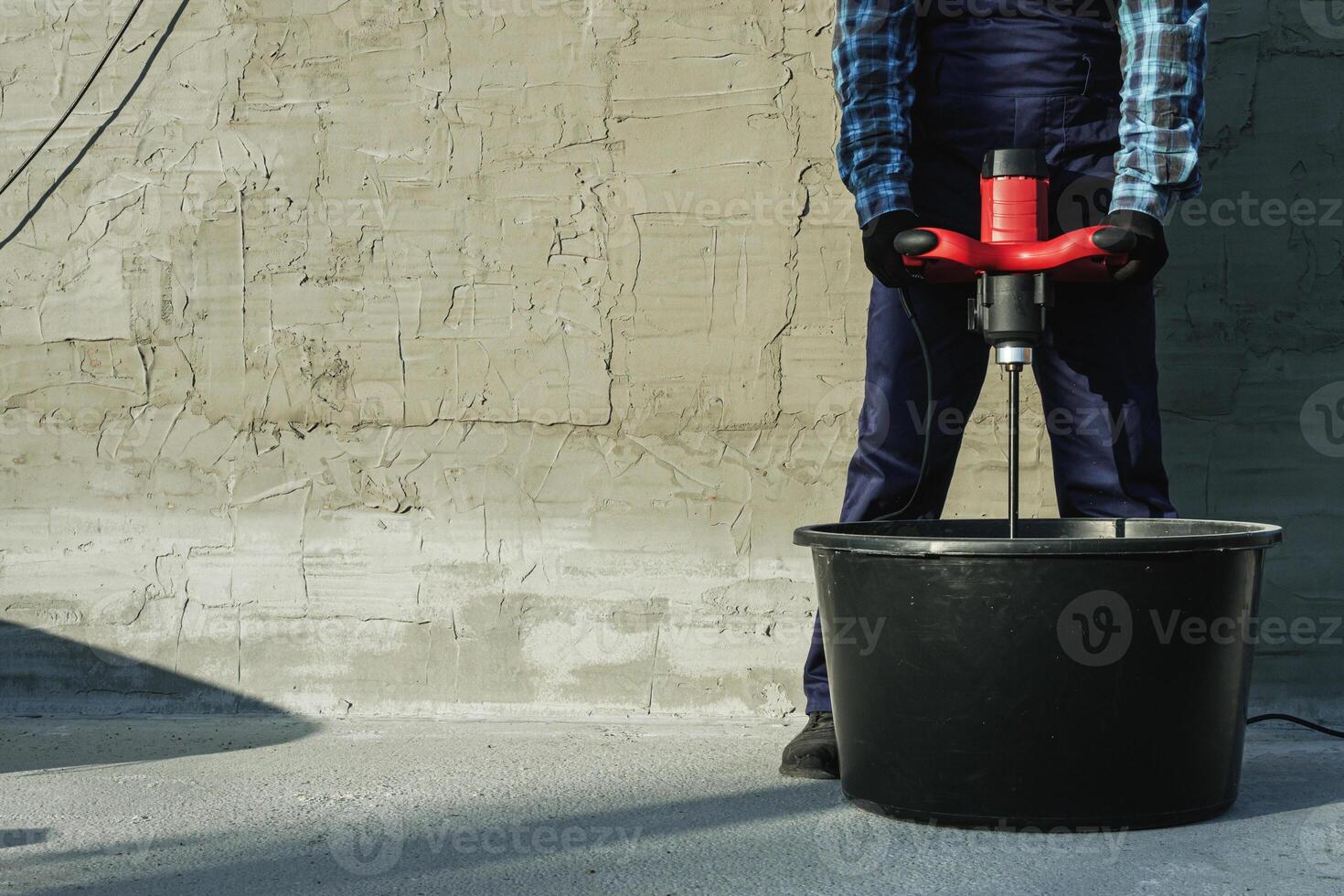 the builder mixes the cement mixture with a mixer photo