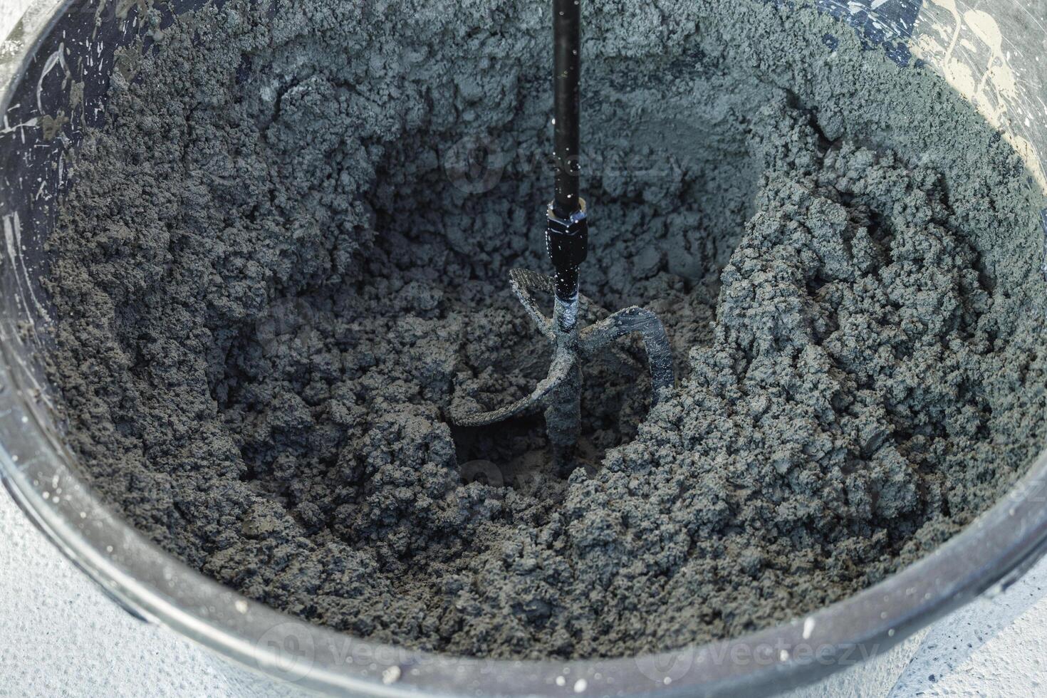 handheld electric concrete mixer on construction site photo