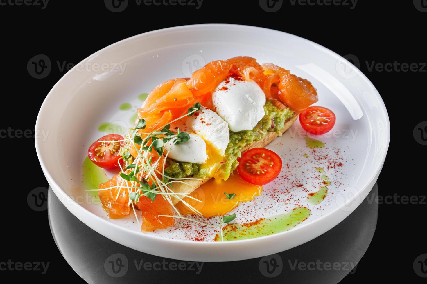 poached egg toast with avocado and salmon on a white plate photo