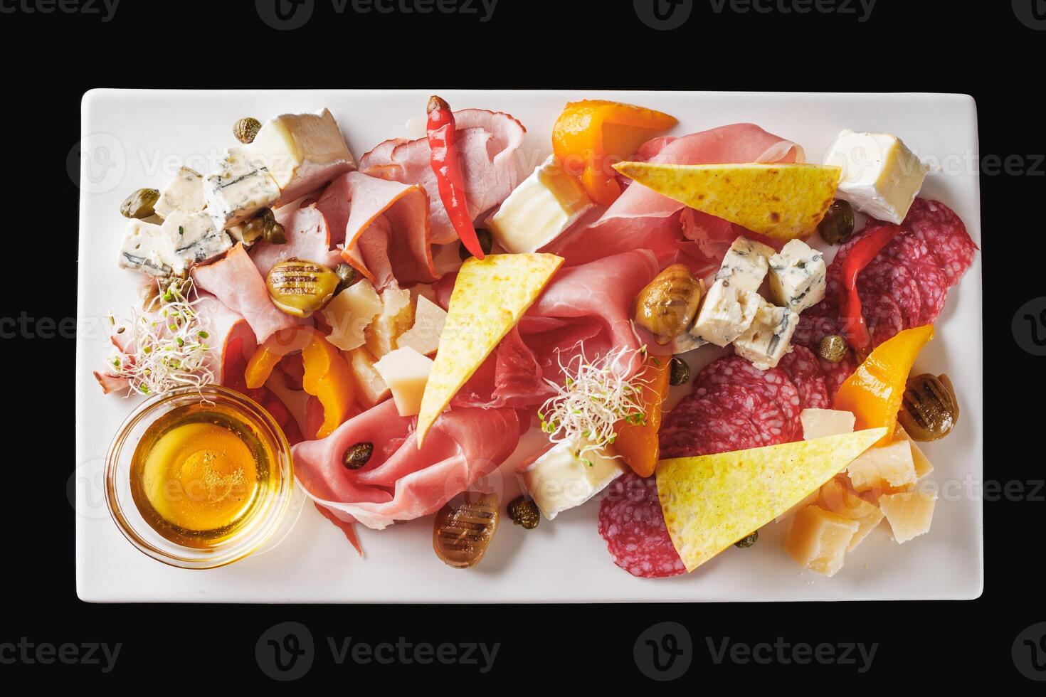 a tray of assorted meat and cheese on a light stone background photo
