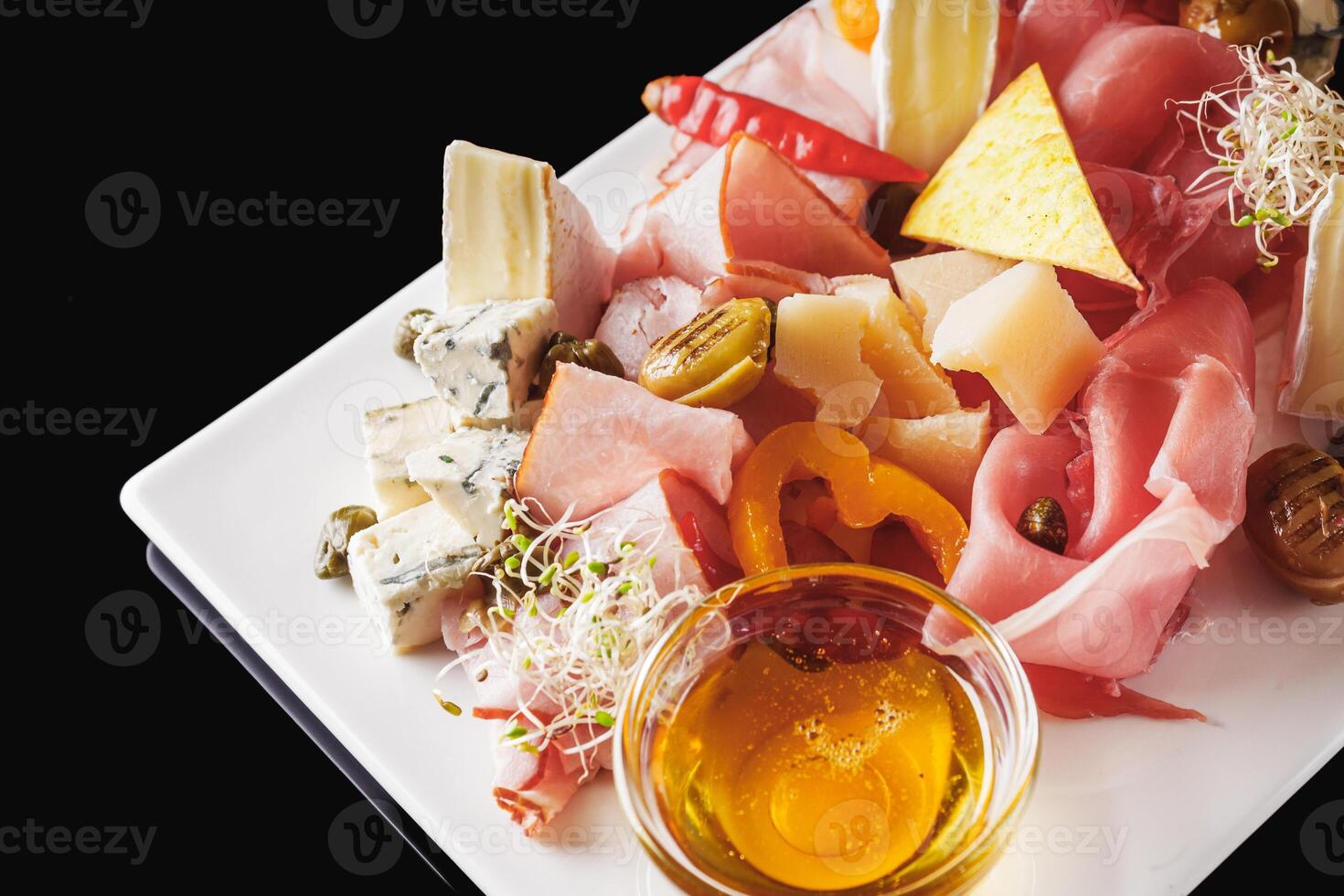 a tray of assorted meat and cheese on a light stone background photo
