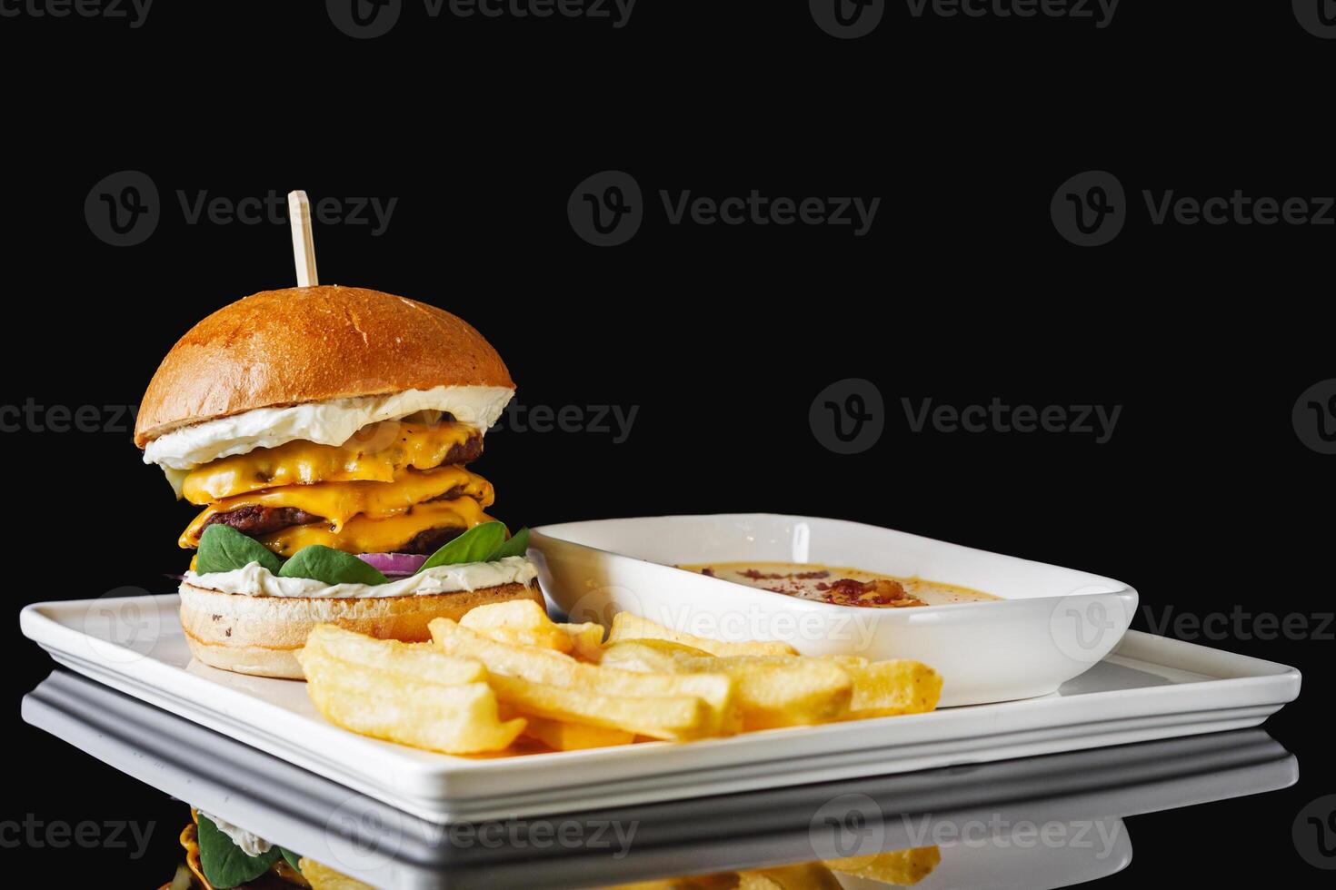 a delicious cheeseburger with three beef cutlets and a cheese bath photo