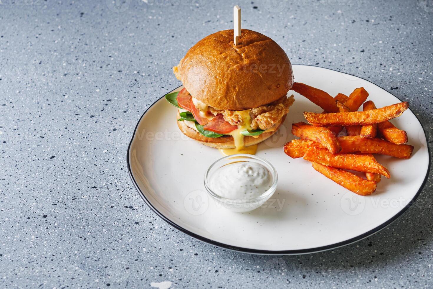 delicious cheeseburger with chicken cutlet and sweet potato fries photo