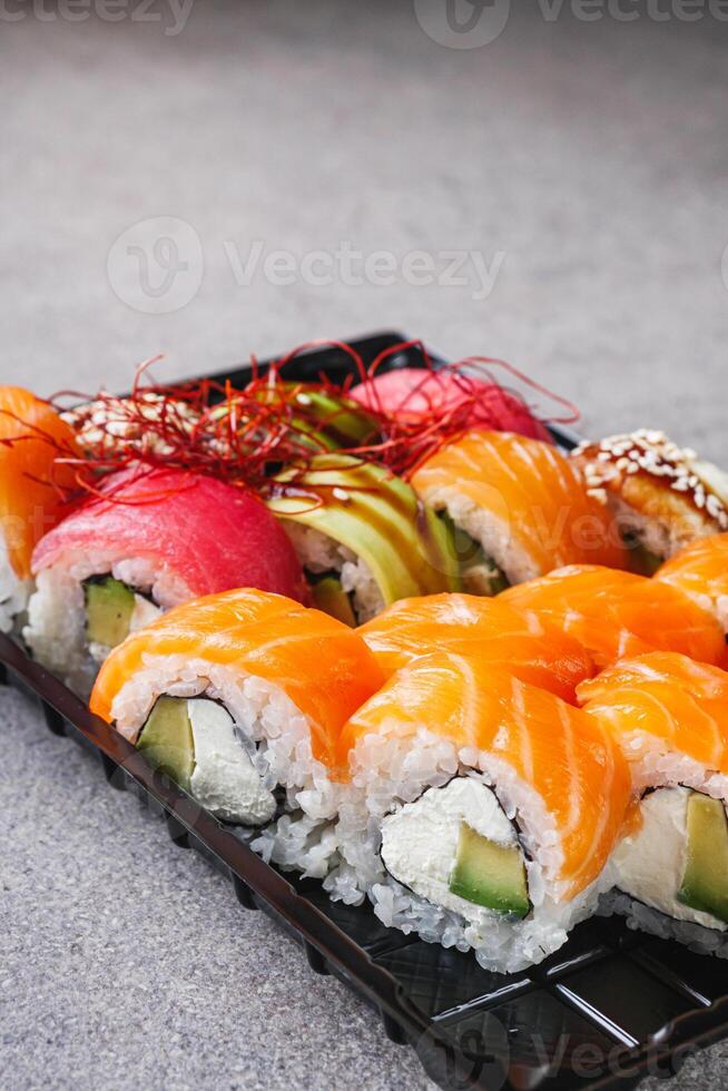 set of delicious fresh sushi roll with salmon avocado cucumber tuna eel Philadelphia cheese photo