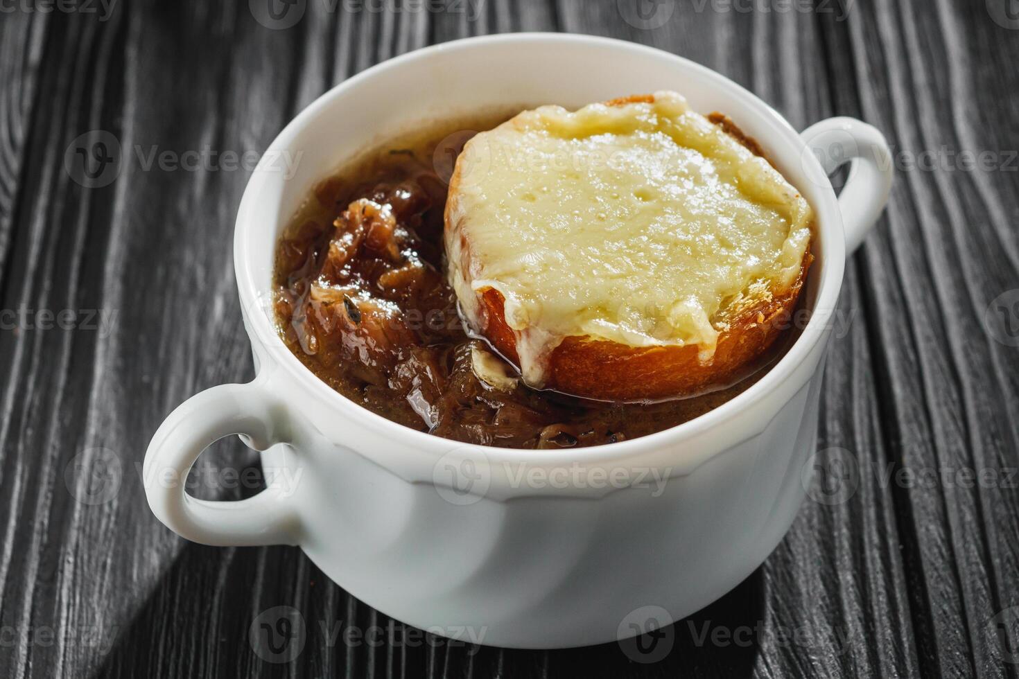 delicious original french onion soup on a black rustic wooden background photo