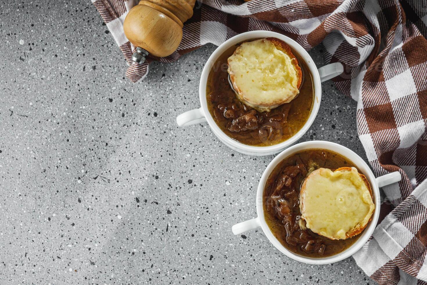 delicious original French onion soup on a light stone background photo