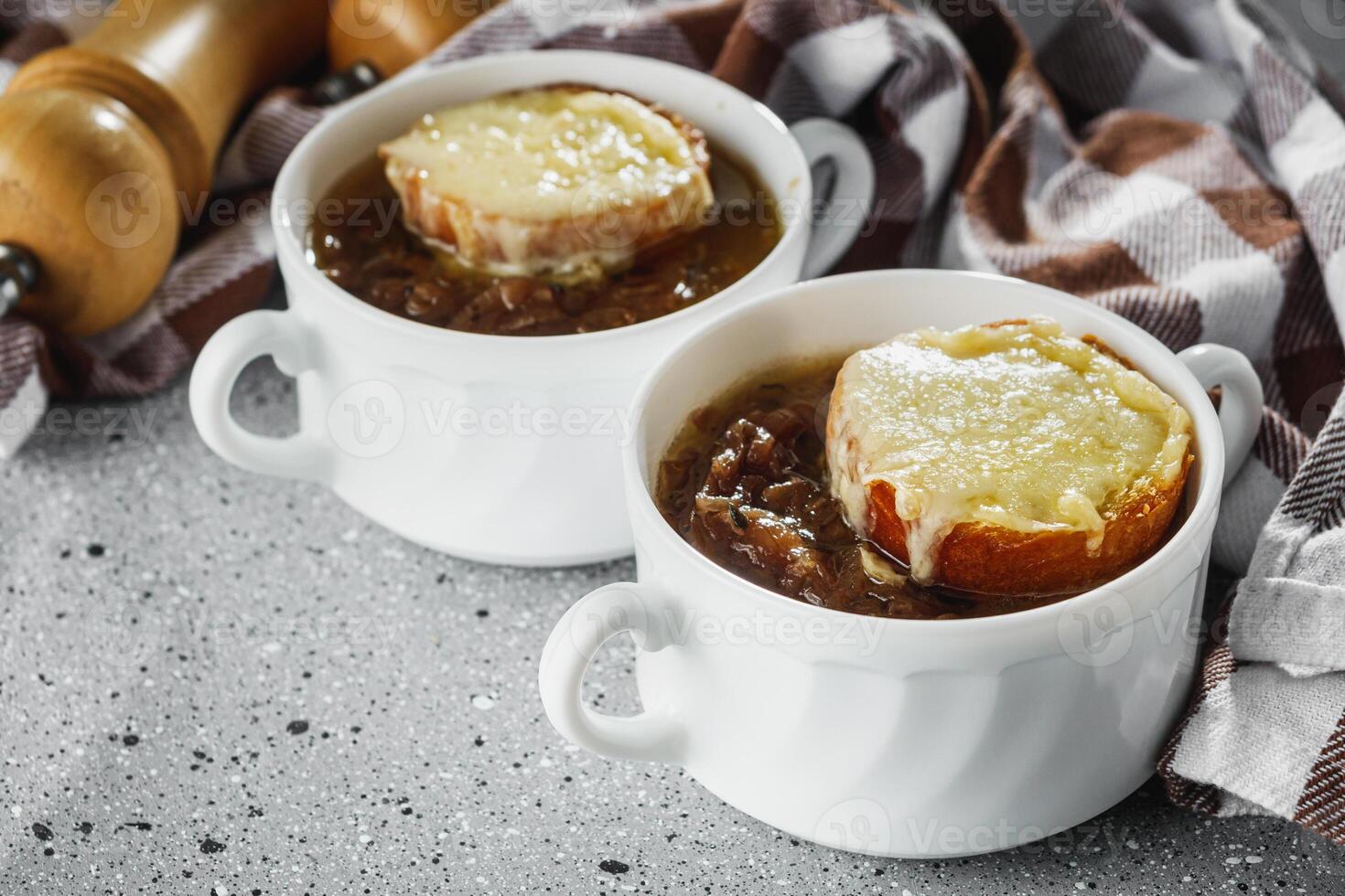 delicious original French onion soup on a light stone background photo
