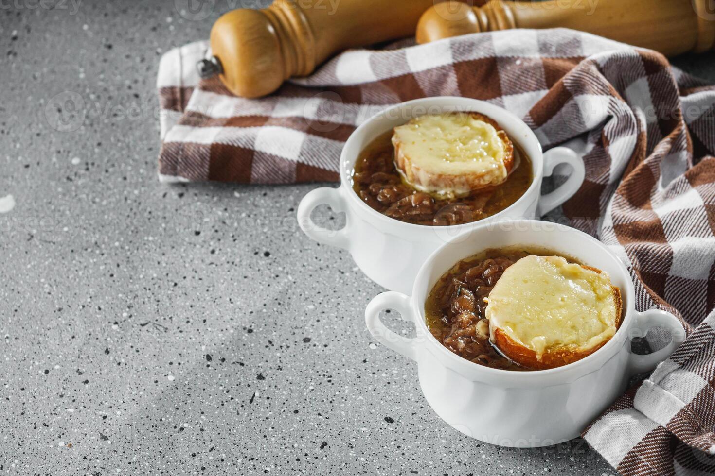 delicious original French onion soup on a light stone background photo