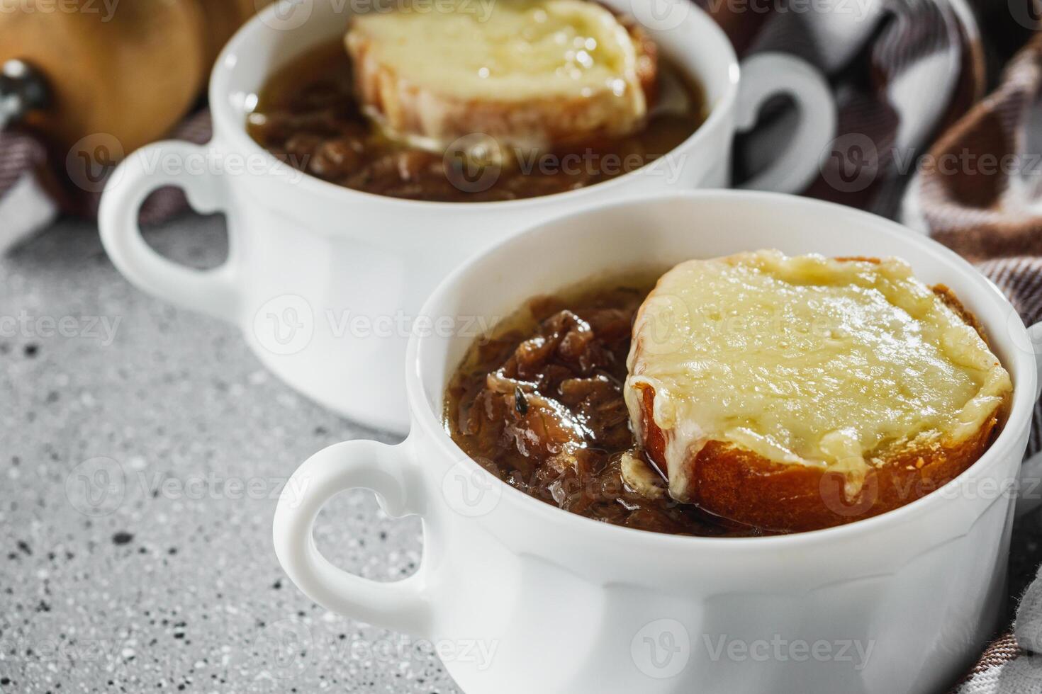 delicious original French onion soup on a light stone background photo