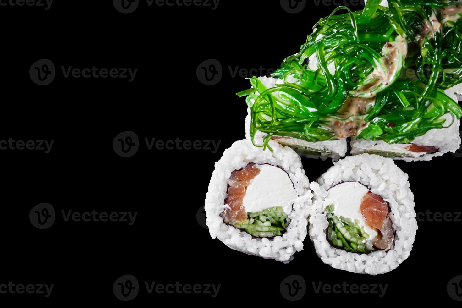 sushi roll with tuna cucumber cream cheese and chuka on a black mirror background photo