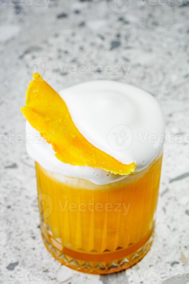 passion fruit cocktail on a gray stone bar counter photo