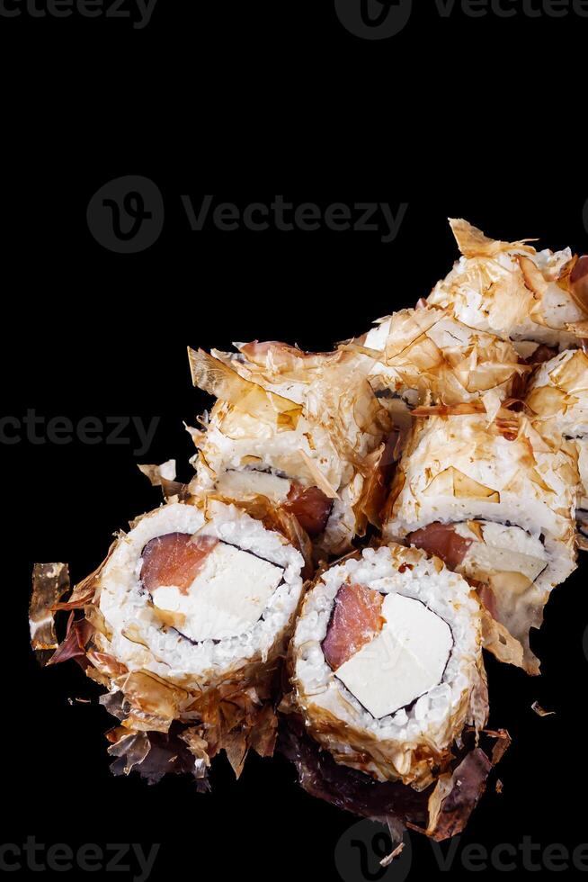 sushi roll with salmon tofu cream cheese on a black mirror background photo