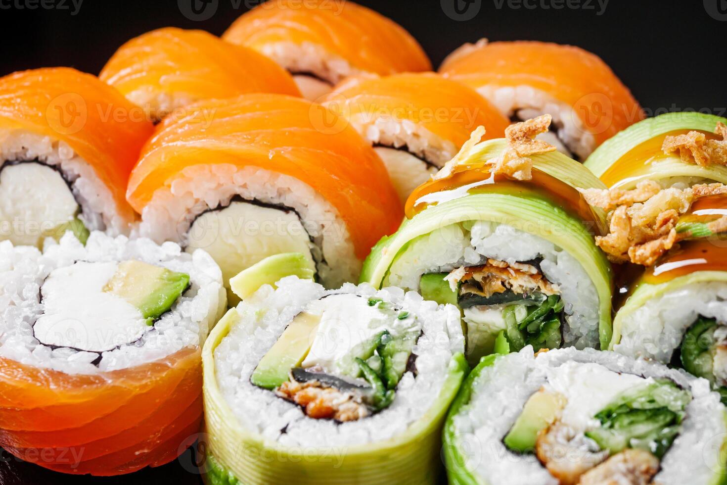 sushi roll green dragon with eel avocado cucumber cream cheese philadelphia set on a black mirror background photo